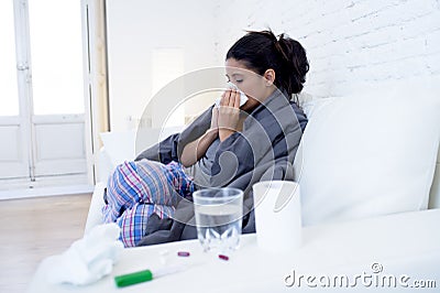 Young attractive hispanic woman lying sick at home couch in cold and flu in gripe disease symptom Stock Photo