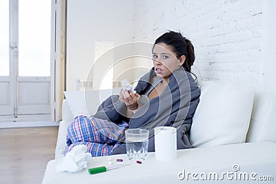 Young attractive hispanic woman lying sick at home couch in cold and flu in gripe disease symptom Stock Photo