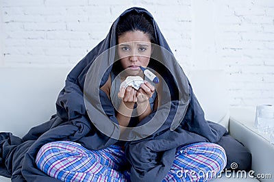 Young attractive hispanic woman lying sick at home couch in cold and flu in gripe disease symptom Stock Photo