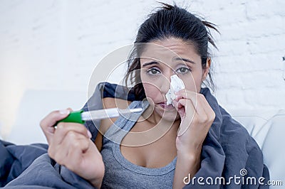 Young attractive hispanic woman lying sick at home couch in cold and flu in gripe disease symptom Stock Photo
