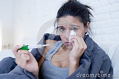 Young attractive hispanic woman lying sick at home couch in cold and flu in gripe disease symptom Stock Photo