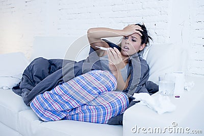 Young attractive hispanic woman lying sick at home couch in cold and flu in gripe disease symptom Stock Photo