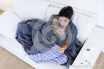 Young attractive hispanic woman lying sick at home couch in cold and flu in gripe disease symptom Stock Photo