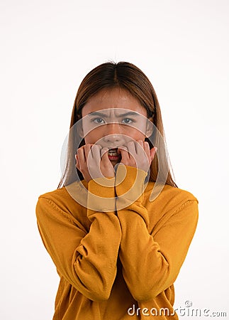 Young attractive nervous scared asian girl bitting her nails in studio Stock Photo