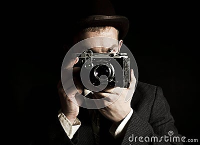 Young and attractive photographer in vintage suit and with retro photo camera. Stock Photo