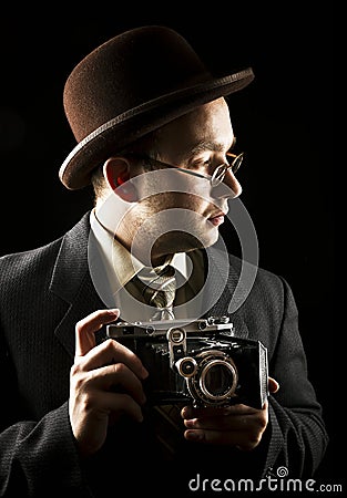 Young and attractive photographer in vintage suit and with retro photo camera. Stock Photo