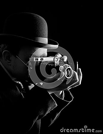 Young and attractive photographer in vintage suit and with retro photo camera. Stock Photo