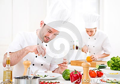 Young attractive professional chef cooking in his kitchen Stock Photo