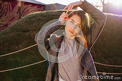 Young attractive short-haired brunette woman posing for a photo in a park Stock Photo