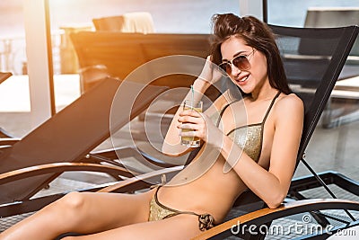 Young attractive slim girl in bikini relaxing on deck chair in wellness spa hotel resort Stock Photo