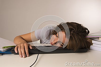 Young attractive student girl or working woman sitting at computer desk in stress sleeping tired exhausted and boring Stock Photo