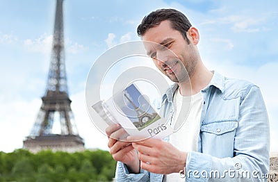 Young attractive tourist reading a guide of Paris Stock Photo