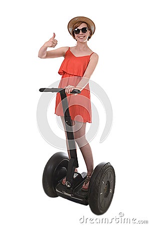 Young attractive tourist woman in chic summer dress smiling happy riding electrical segway Stock Photo