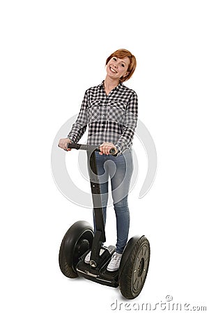 Young attractive tourist woman with red hair wearing jeans smiling happy riding electrical segway Stock Photo