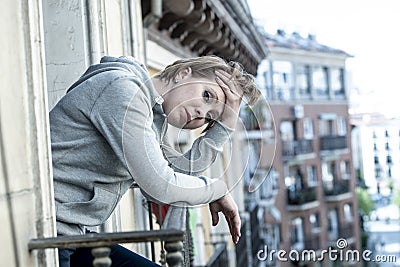 Young attractive unhappy woman with depression and anxiety feeling miserable and hopeless on home balcony Stock Photo