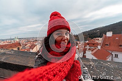 Young Attractive Woman With Big Cozy Red Scarf And Red Hat On Beautiful Prague Cityscape Stock Photo