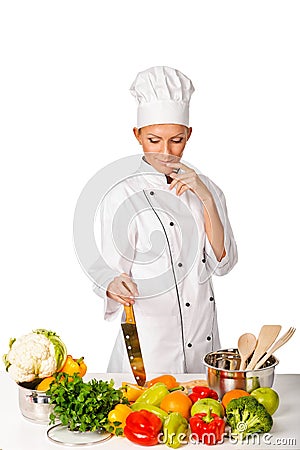 Young attractive woman chef thinking. Variety of fresh vegetabl Stock Photo