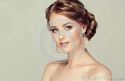 Young attractive woman is demonstrating deep blonde hair gathered in exquisite hairstyle. Stock Photo