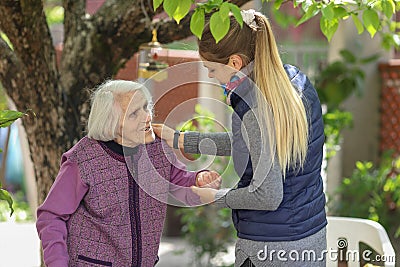 Young attractive woman embracing old grandmother outdoor. Female - generations - love Stock Photo