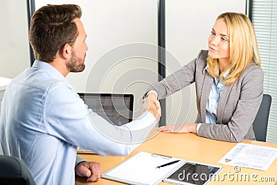 Young attractive woman handshaking at the end of a job interview Stock Photo