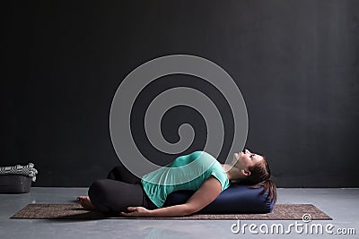 Woman practicing yoga concept, lying in Reclined Butterfly exercise Stock Photo