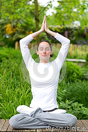 Young attractive woman practising yoga in a park Stock Photo