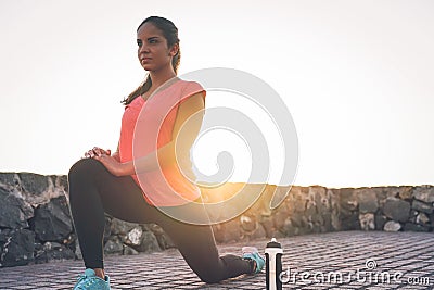 Young attractive woman stretching next the beach during a magnificent sunset - Sporty health girl workout outdoor Stock Photo