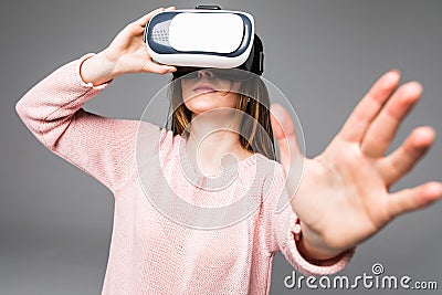 Young attractive woman wearing headset VR virtual reality vision goggles watching video happy amazed and shocked in new advanced t Stock Photo