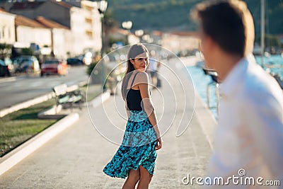 Young attractive woman flirting with a man on the street.Flirty smiling woman looking back on a handsome man.Female attraction Stock Photo