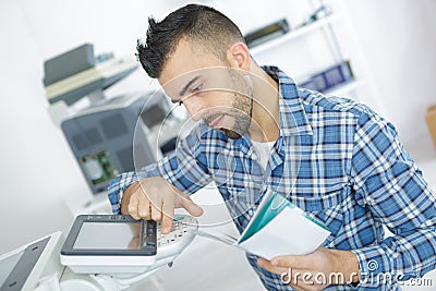 Young attractive worker man working using printmaking device Stock Photo