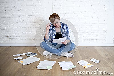 Woman at living room floor with calculator and bank and bills paperwork and documents doing domestic financial accounting Stock Photo