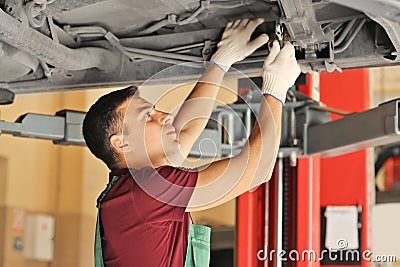 Young auto mechanic repairing car in service center Stock Photo