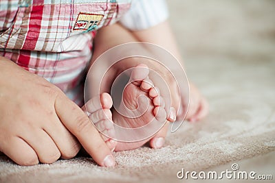 Young baby foot. Newborn boy indoors Stock Photo
