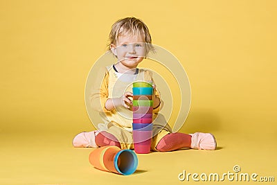 Young Baby Girl in Yellow Dress on Yellow Background Stock Photo