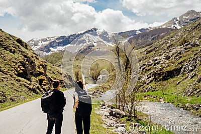 Young backpacker hiker couple enjoying relaxing mountain hike.Active hiking trip vacation.Reconnecting with nature.Climbers Stock Photo