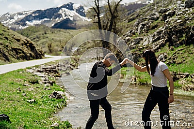 Young backpacker hiker couple enjoying relaxing mountain hike.Active hiking trip vacation.Walking by the mountain stream.Climbers Stock Photo