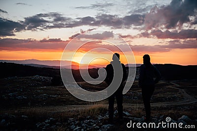 Young backpacker hiker couple enjoying relaxing mountain hike at sunset.Active hiking camping trip vacation.Reconnecting with Stock Photo