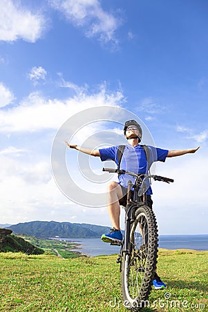 Young backpacker sitting on a mountain bike and relaxing pose Stock Photo