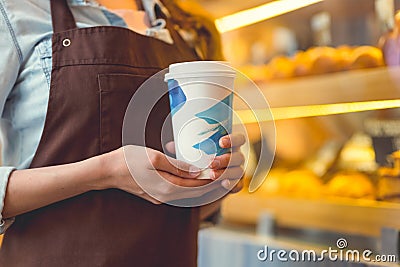 Young baker in uniform with coffee Stock Photo
