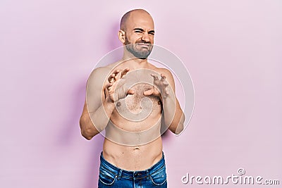 Young bald man standing shirtless disgusted expression, displeased and fearful doing disgust face because aversion reaction Stock Photo