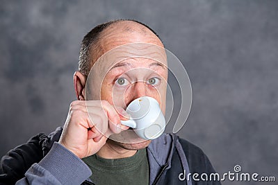 Young baldheaded man drinking coffee Stock Photo