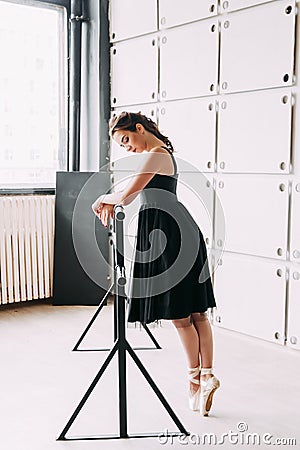 Young ballerina standing on poite at barre in ballet class Stock Photo