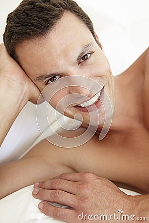 Young Bare Chested Man Relaxing On Bed Stock Photo