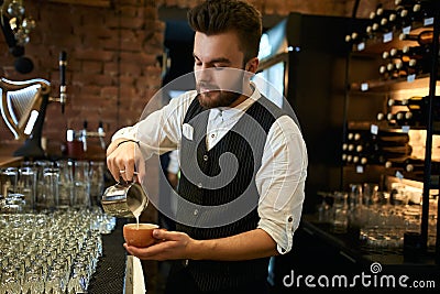 Young barista enjoying making cuppuchino at workplace Stock Photo