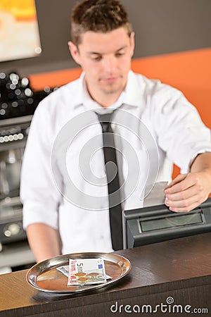 Young bartender in uniform taking cash euro Stock Photo