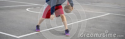 young basketball player training to dribble outdoor on the asphalt court in summer seasons Stock Photo