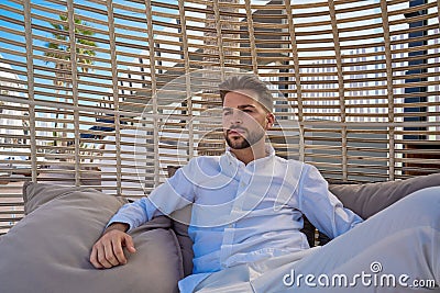 Young beard man relaxed in a beach parasol Stock Photo