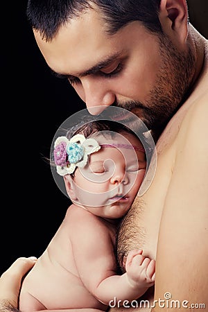 Young bearded father gently holds on his chest newborn baby daughter Stock Photo