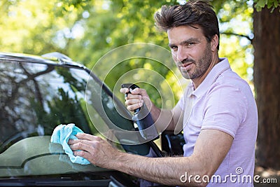 young bearded man cleaning car with cloth Stock Photo