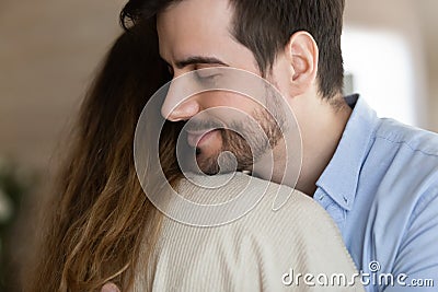 Young bearded man embracing wife after reconcile. Stock Photo